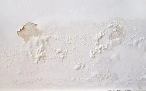 water damage on wall, paint peeling and bubbling