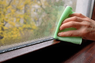 hand wiping moisture from window